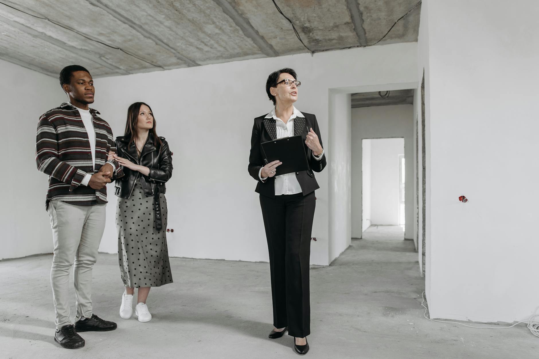 Agent nieruchomości pokazuje niedokończone mieszkanie potencjalnym inwestorom