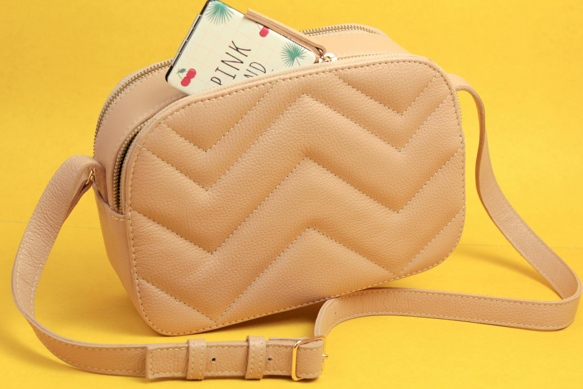 Beżowa elegancka torebka na intensywnie żółtym tle