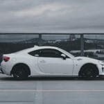 Białe sportowe coupé na dachu miejskiego parkingu