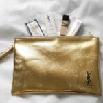 Luksusowe kosmetyki YSL ułożone na złotej kosmetyczce