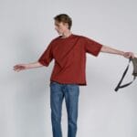 Młody mężczyzna w casualowej stylizacji z nerką w studiu