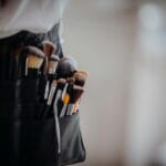 Zbliżenie na profesjonalne pędzle do makijażu w pasie wizażysty