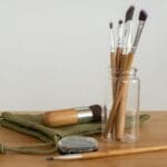 Zestaw ekologicznych pędzli do makijażu w szklanym słoiku na drewnianym stole