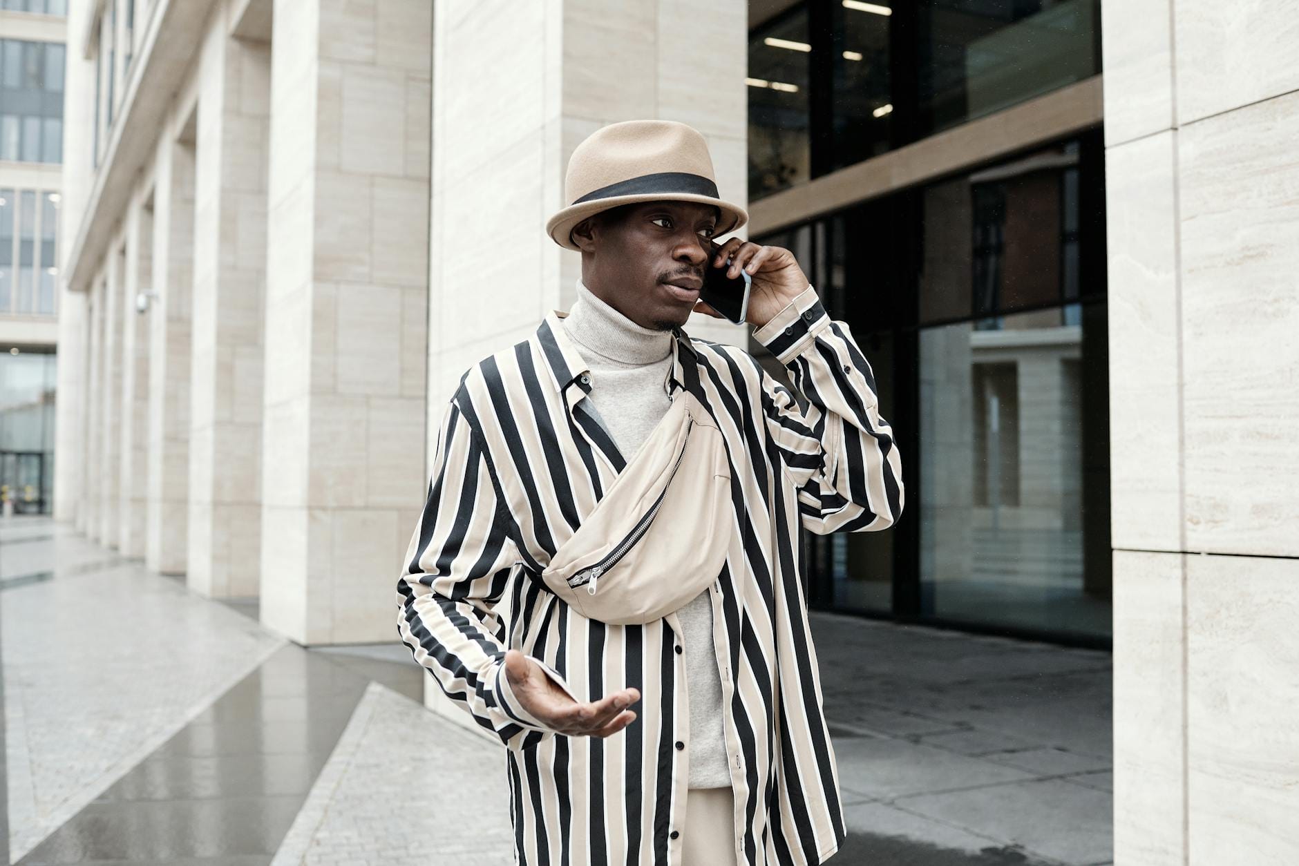 Mężczyzna w pasiastym stroju na ulicy rozmawia przez telefon