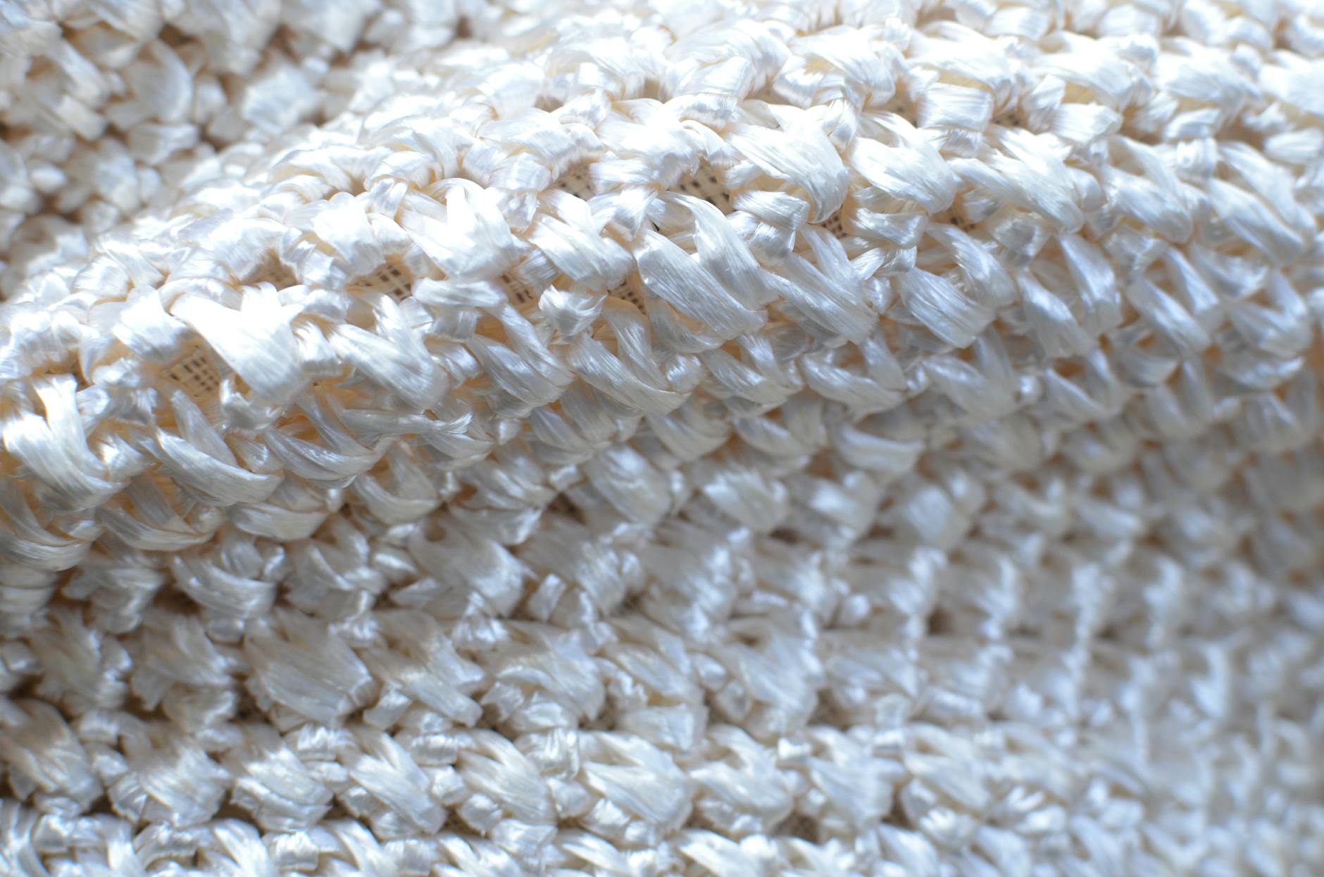 Sploty dzianin i tkanin: co będzie się rozciągać w gotowej torebce Jasny beżowy dzianinowy materiał o wyraźnym splocie z bliska