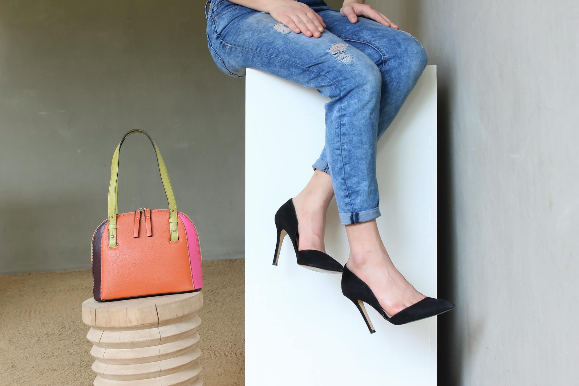 Jeansy z czarnymi szpilkami i kolorową torebką handmade w miejskiej stylizacji