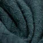 Zbliżenie faktury niebieskiej dzianiny ilustrującej rozciągliwość materiału