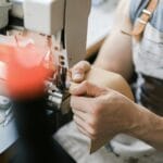 Zbliżenie na szycie skóry torebki na przemysłowej maszynie