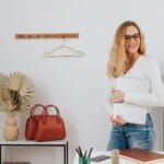 Elegancka kobieta z laptopem ogląda torebki w butiku
