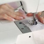 Krawcowa szyje tkaninę na maszynie w dom pracowni